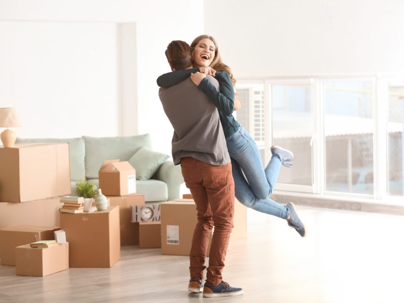 Young happy couple in room with moving boxes at new home Young happy couple in room with moving boxes at new home
